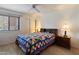 Bedroom with a queen bed and a light colored quilt, side tables, ceiling fan, and blinds on window at 4015 N 78Th St # 135, Scottsdale, AZ 85251