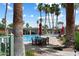 Community pool area featuring lounge chairs, tables, and palm trees on a sunny day at 4015 N 78Th St # 135, Scottsdale, AZ 85251