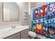 bathroom with superhero-themed shower curtain, vanity with stylish fixtures and white shelving at 42726 N Livingstone Way, Anthem, AZ 85086