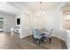 Elegant dining room featuring modern gray flooring, stylish chandelier, and comfortable seating for four at 42726 N Livingstone Way, Anthem, AZ 85086