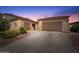 Charming home featuring a three-car garage, desert landscaping, and a welcoming red front door at 42726 N Livingstone Way, Anthem, AZ 85086