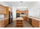 Well-equipped kitchen featuring stainless steel appliances, wooden cabinetry, and center island at 42726 N Livingstone Way, Anthem, AZ 85086