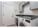 Laundry room features gray cabinets and a new washer and dryer, making chores a breeze at 42726 N Livingstone Way, Anthem, AZ 85086