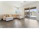 Open concept living room with gray wood flooring and sliding glass doors to the backyard at 42726 N Livingstone Way, Anthem, AZ 85086