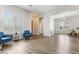 Spacious living room with light gray flooring, plantation shutters, and open access to the dining area at 42726 N Livingstone Way, Anthem, AZ 85086