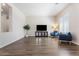 Bright living room featuring modern gray flooring, a TV, and comfortable blue armchairs at 42726 N Livingstone Way, Anthem, AZ 85086