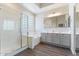 Elegant bathroom features a soaking tub, glass shower, dual vanity, and modern lighting at 42726 N Livingstone Way, Anthem, AZ 85086