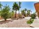 Landscaped backyard with desert plants, palm trees, patio, fire pit and hot tub under a clear blue sky at 4345 E Annette Dr, Phoenix, AZ 85032