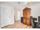 Bedroom featuring wood-look floors, cream walls, and wooden wardrobe with a peak into a connecting room at 4345 E Annette Dr, Phoenix, AZ 85032