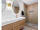 Modern bathroom features sleek double vanity, elegant mirrors and tiled walk-in shower at 4400 N 20Th St, Phoenix, AZ 85016