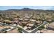 Neighborhood aerial view showcasing homes with pools and landscaping against a backdrop of mountains under a blue sky at 4423 W Lodge Dr, Laveen, AZ 85339