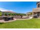 This backyard features lush green grass, a rock water feature, a pool, and an outdoor kitchen at 4423 W Lodge Dr, Laveen, AZ 85339