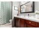 Bathroom with dark wood cabinets, white counter, and decorative mirror at 4423 W Lodge Dr, Laveen, AZ 85339