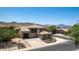 Charming exterior elevation of home with a well-manicured front yard, desert landscaping, and mountain views at 4423 W Lodge Dr, Laveen, AZ 85339