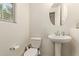 Bathroom with pedestal sink, round mirror, and white walls at 4807 W St Anne Ave, Laveen, AZ 85339