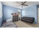 Light blue bedroom with ceiling fan, gray couch, and toddler bed with cube storage at 4807 W St Anne Ave, Laveen, AZ 85339