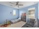 Light blue bedroom with ceiling fan, gray couch, and toddler bed with a playful arrangement at 4807 W St Anne Ave, Laveen, AZ 85339