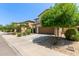 Two-story tan home with two-car garage and tree-lined street at 4807 W St Anne Ave, Laveen, AZ 85339