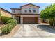 Tan two-story home with a well-maintained yard and a two-car garage at 4807 W St Anne Ave, Laveen, AZ 85339