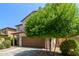 Two-story tan home with two-car garage and mature landscaping at 4807 W St Anne Ave, Laveen, AZ 85339