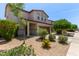 Well-maintained two-story tan home with landscaped front yard and gravel at 4807 W St Anne Ave, Laveen, AZ 85339