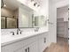 Modern bathroom featuring double sinks, a large mirror, and a walk-in closet at 5023 W Hardtack Trl, Laveen, AZ 85339