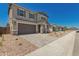 New two-story home featuring a spacious driveway, a two-car garage, and tasteful stone accents at 5023 W Hardtack Trl, Laveen, AZ 85339