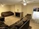 Spacious living room has a brick fireplace, plush carpet, ceiling fans, and natural lighting at 564 N Santa Anna St, Mesa, AZ 85201