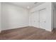 Clean bedroom featuring a closet with sliding doors, hardwood floors, and white walls at 5744 E Lowden Rd, Cave Creek, AZ 85331