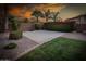 Backyard sport court with basketball hoop, lush landscaping, and a privacy wall at sunset at 7156 S Forest Ave, Gilbert, AZ 85298