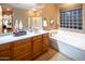 Bright bathroom features a soaking tub, separate shower, and a vanity with white countertops at 7156 S Forest Ave, Gilbert, AZ 85298