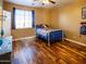 Fun ' bedroom features wood floors, a window, and pops of color perfect for playtime and restful nights at 7156 S Forest Ave, Gilbert, AZ 85298