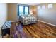 Bedroom featuring a metal bed frame, blue curtains, and hardwood floors at 7156 S Forest Ave, Gilbert, AZ 85298