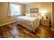 Comfortable bedroom featuring warm wood floors, a large window, and neutral décor create a cozy space at 7156 S Forest Ave, Gilbert, AZ 85298