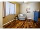 Comfortable bedroom with wood floors features a cozy sitting area, a window, and neutral décor at 7156 S Forest Ave, Gilbert, AZ 85298