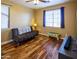 Bedroom featuring wood floors and a window, furnished with a comfortable futon, and table at 7156 S Forest Ave, Gilbert, AZ 85298