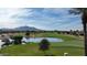 Scenic golf course view with a lake, lush greenery, mountains, and blue skies in the background at 7156 S Forest Ave, Gilbert, AZ 85298