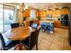 Inviting kitchen with granite countertops, wood cabinets, a central island with seating, and access to the patio at 7156 S Forest Ave, Gilbert, AZ 85298