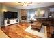 Comfortable living room featuring a stone fireplace, hardwood floors, a plush leather sectional, and abundant natural light at 7156 S Forest Ave, Gilbert, AZ 85298