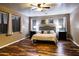 Spacious bedroom boasts wood floors, a ceiling fan, and lots of natural light from its large windows at 7156 S Forest Ave, Gilbert, AZ 85298