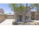 Charming two-story home with a covered entry, green door, desert landscaping and an attached garage at 7227 E Northridge St, Mesa, AZ 85207