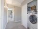 Neutral-toned hallway leading to multiple rooms, with carpeted floors and a laundry area behind closet doors at 7227 E Northridge St, Mesa, AZ 85207