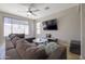This living room features a ceiling fan, large windows, and a comfortable, oversized sectional couch at 7227 E Northridge St, Mesa, AZ 85207