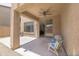 Covered patio area with comfortable seating, ceiling fan, and view into the home's interior at 7227 E Northridge St, Mesa, AZ 85207