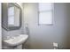 Stylish powder room with a modern sink, a decorative mirror, and a window with a blind at 7227 E Northridge St, Mesa, AZ 85207