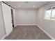 Neutral bedroom with a sliding barn door, light gray walls, plush carpet, and ample natural light from the window at 7840 N 7Th St # 15, Phoenix, AZ 85020