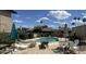 Community pool area with lounge chairs and dining furniture, surrounded by lush greenery under a bright sky at 7840 N 7Th St # 15, Phoenix, AZ 85020