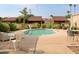 Inviting community pool surrounded by lounge chairs, tables, and lush greenery, perfect for relaxation at 7840 N 7Th St # 15, Phoenix, AZ 85020