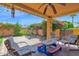 Backyard with a covered patio, brick floor and green grass area, nice landscaping, swing in background at 1040 E Clinton St, Phoenix, AZ 85020