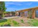 Spacious backyard featuring a covered patio and mature landscaping, including flower bushes and palm trees at 1040 E Clinton St, Phoenix, AZ 85020